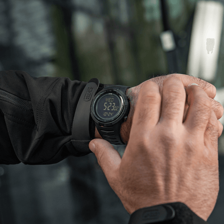 M-Tac Tactical Watch 2147 on wrist in nature, rugged design for outdoor and tactical use with features like compass and LED lighting.