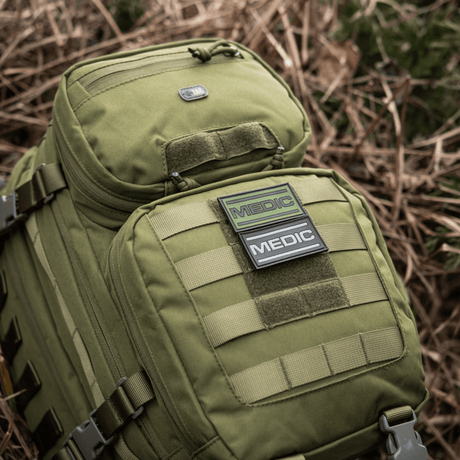M-Tac Medic PVC 3D tactical patch on green backpack, flexible PVC with velcro fastener. 70x35mm, suitable for medical personnel.