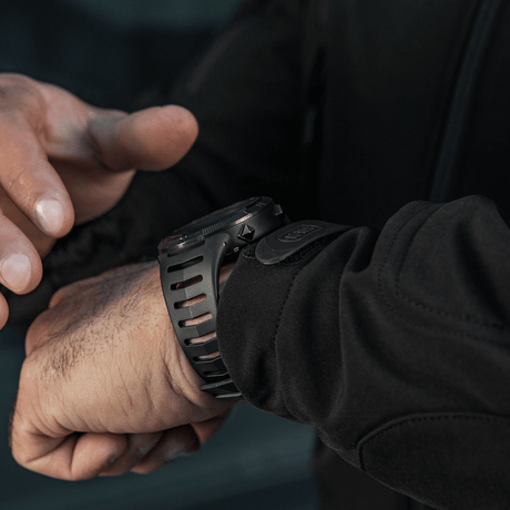 Person adjusting M-Tac Tactical Watch 2147 on wrist. Ideal for outdoor and tactical use with rugged design and practical features.