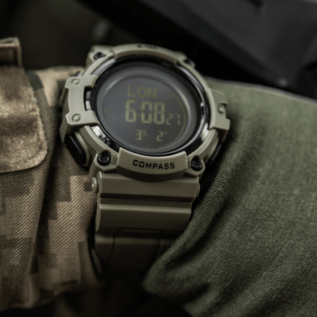 M-Tac Tactical Watch with Compass 2233 on a camouflage sleeve, rugged design with LED backlight and compass, suitable for outdoor and tactical use.