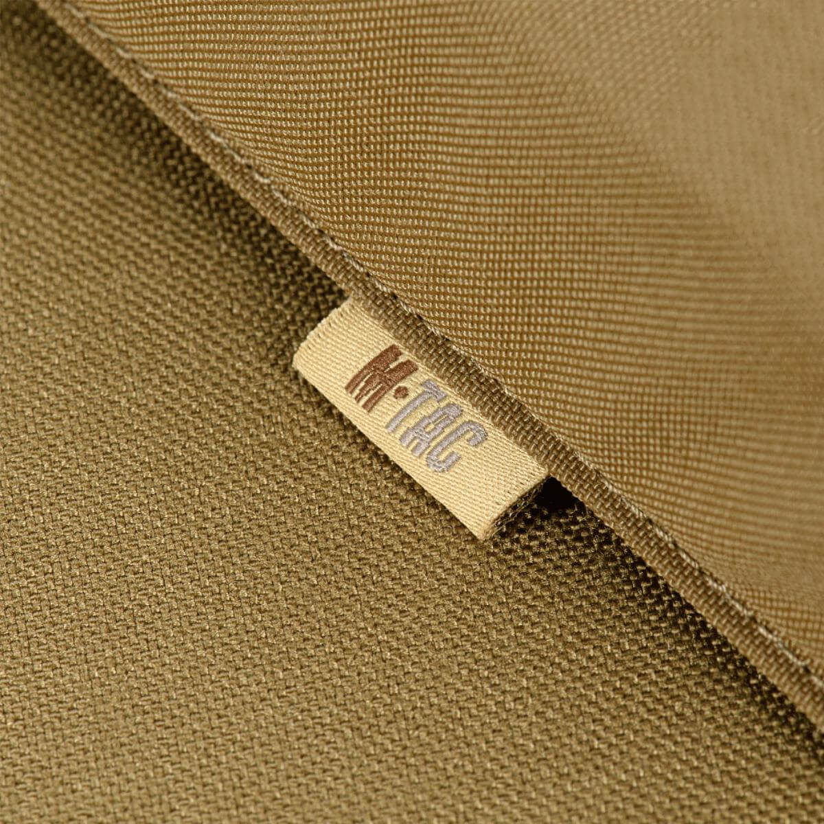 Mærkat på M-Tac taske til Bundeswehr liggeunderlag i nærbillede, viser holdbart materiale og M-Tac branding.