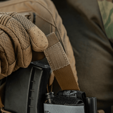 M-Tac Tourniquet Pouch Elastic Gen.5 i brug på taktisk udstyr, med hurtig adgang og sikker fastgørelse til CAT tourniquet.