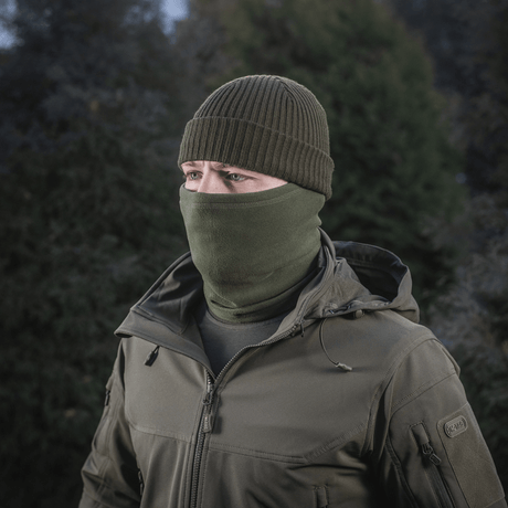 Person iført M-Tac Tube Scarf Polartec i olivenfarve til udendørs aktiviteter om vinteren.