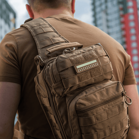 M-Tac Patch Flag 25x80 Mini Squares on a tactical backpack, robust Cordura 500D, ideal for clothing and gear, mounted with velcro in urban surroundings.