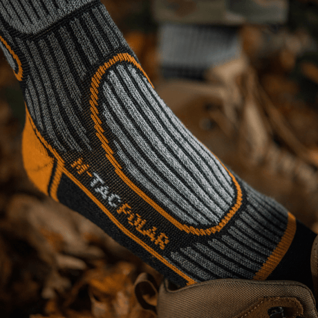M-Tac Sokker Polar Merino 40% designet til udendørs aktiviteter med merinould for varme og komfort, vist i naturligt miljø.