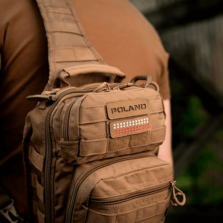 Man wearing a brown bag with M‑Tac Patch Poland End-to-End 25x80 in Cordura 500D attached with Velcro, showing laser engraving.