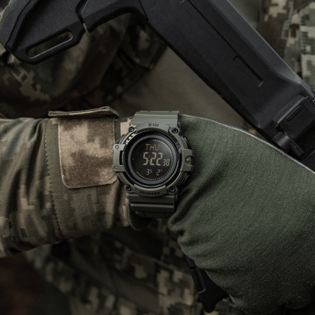M-Tac Tactical Watch with Compass 2233 worn with tactical gear by a person, suitable for outdoor and tactical use, with LED backlight.