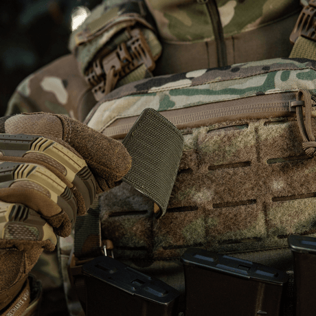 Soldier in camouflage holding M-Tac Patch Ukraine Flag with coat of arms with Velcro on gear.