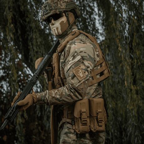 Tactical soldier wearing M-Tac Patch Face of War (Embroidered) on the sleeve, inspired by the Vietnam War 'card of death', in camouflage clothing.