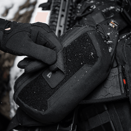 Tactical gear with M-Tac AR-15 223/5,56 Laser Cut Patch in snowy environment.