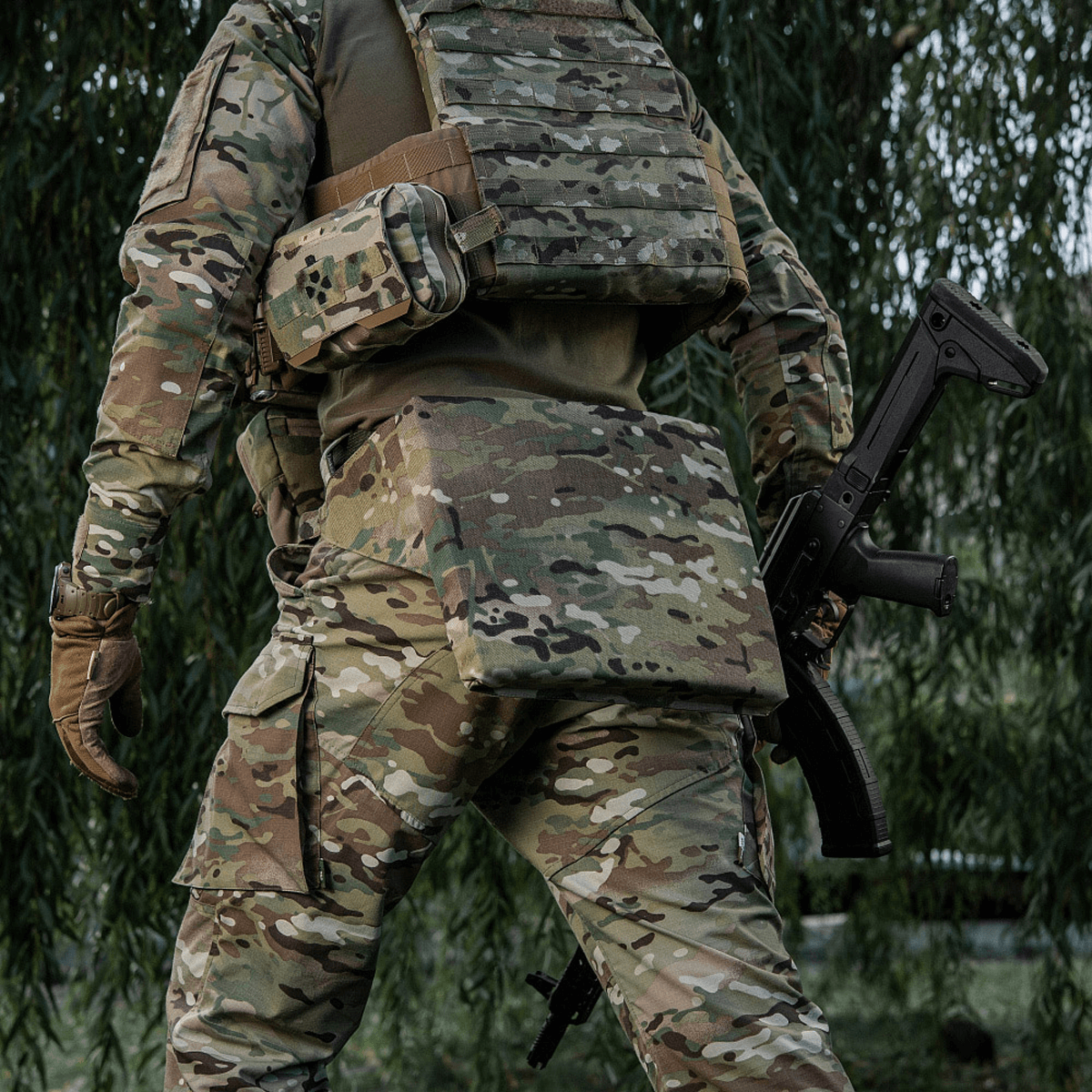 M-Tac Siddeunderlag med Bælte – Multicam i brug i feltforhold, designet til beskyttelse mod kulde og fugt for soldater og friluftsentusiaster.