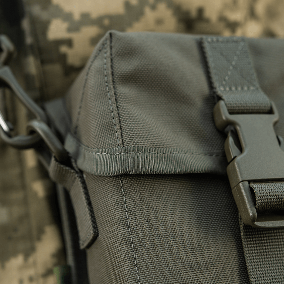 Nærbillede af M-Tac Taske til Natkikkert PVS-14 med fastex-lukning og elastiske stropper i camouflage baggrund