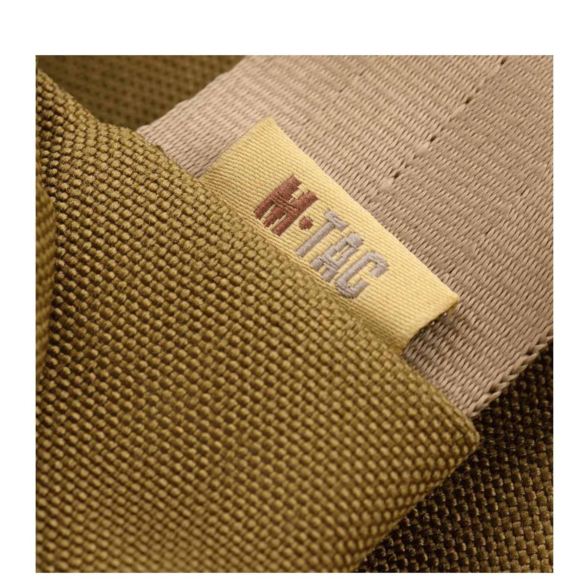Nærbillede af M-Tac Carry Sling Taske Elite Gen.IV med Velcro, der viser mærket i beige og olivengrønne nuancer.