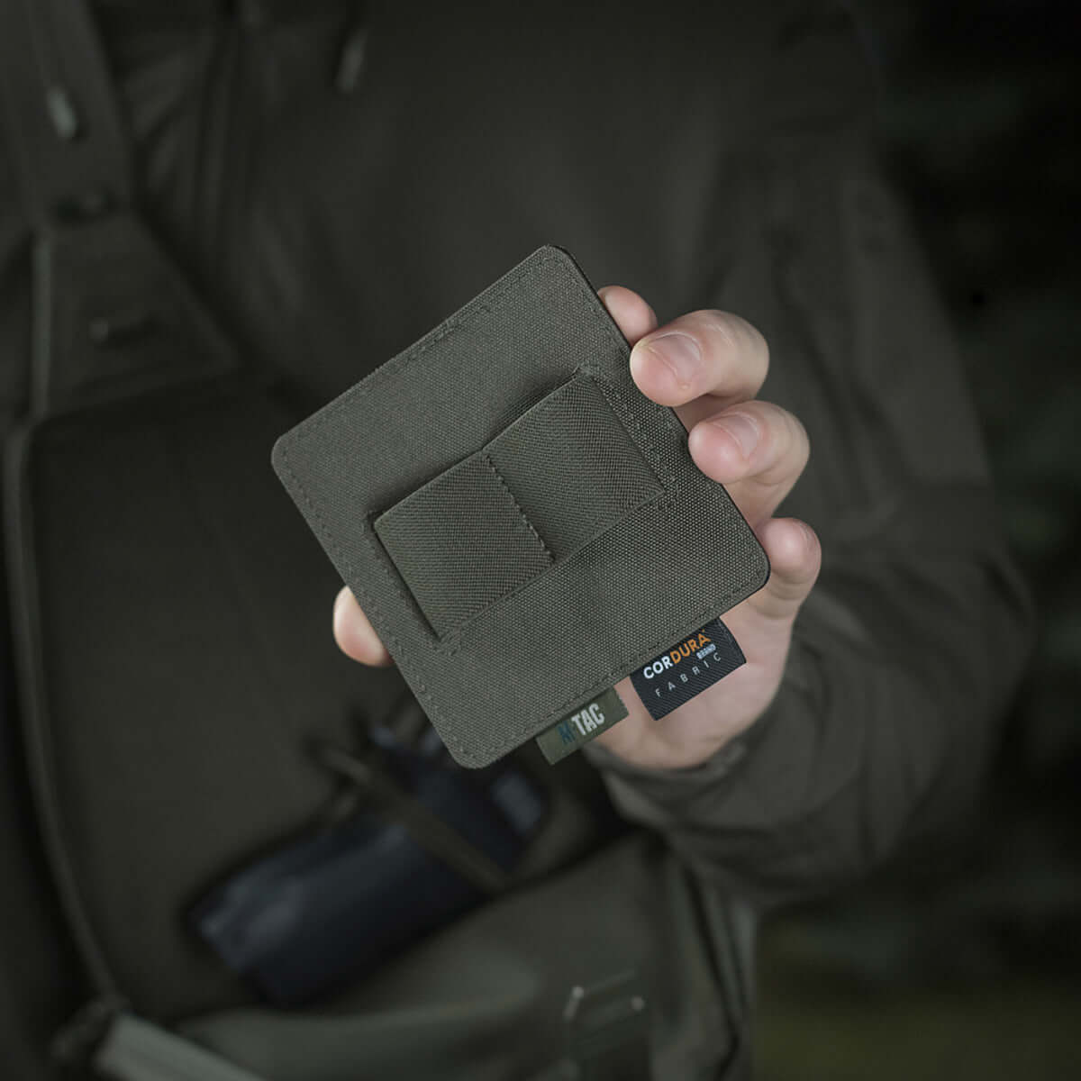 Person holding M-Tac Double Mag Pouch Hook Backed Magazine, showcasing the compact design suitable for various gear.