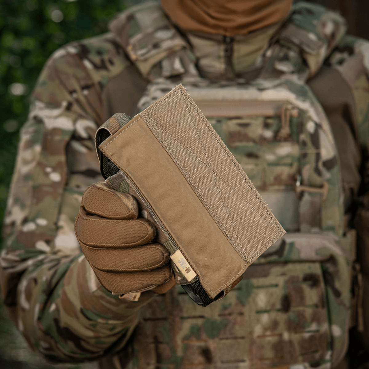M-Tac Tourniquet Pouch Elastisk VELCRO Gen.II i camoufleret omgivelser, holdt af taktisk udstyret person
