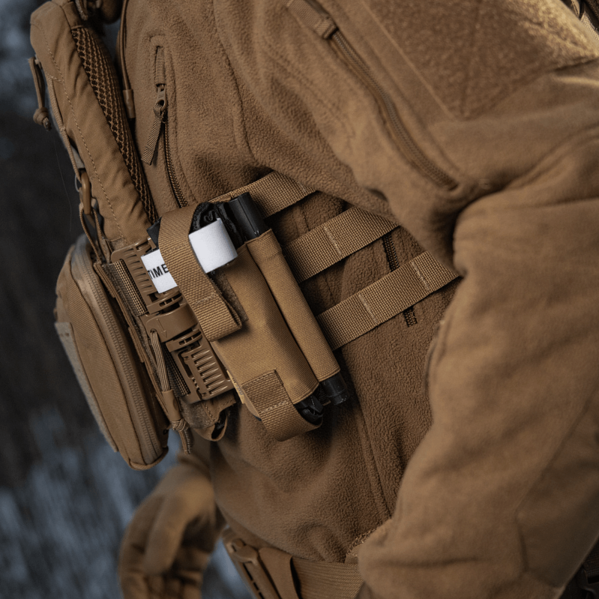 M-Tac Elastisk Tourniquet Pouch Molle Gen.III monteret på taktisk udstyr i brun Cordura Squadron materiale.