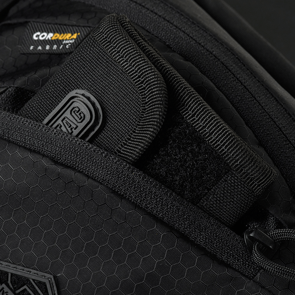 Nærbillede af M-Tac Sphaera Hex Hardsling Taske Gen.II Elite med Cordura Hex polyester og rum til skjult bæring, lynlåsdetaljer.