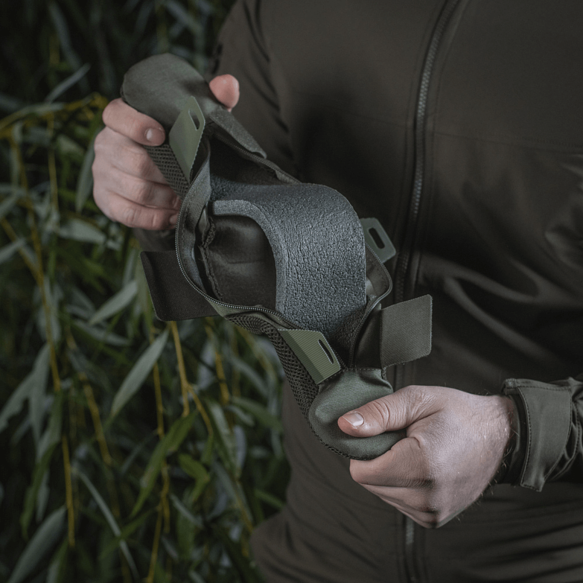 Person holder M‑Tac Skulderremspude 50 mm Elite lavet af slidstærkt Cordura med 3D mesh for komfort og vægfordeling.