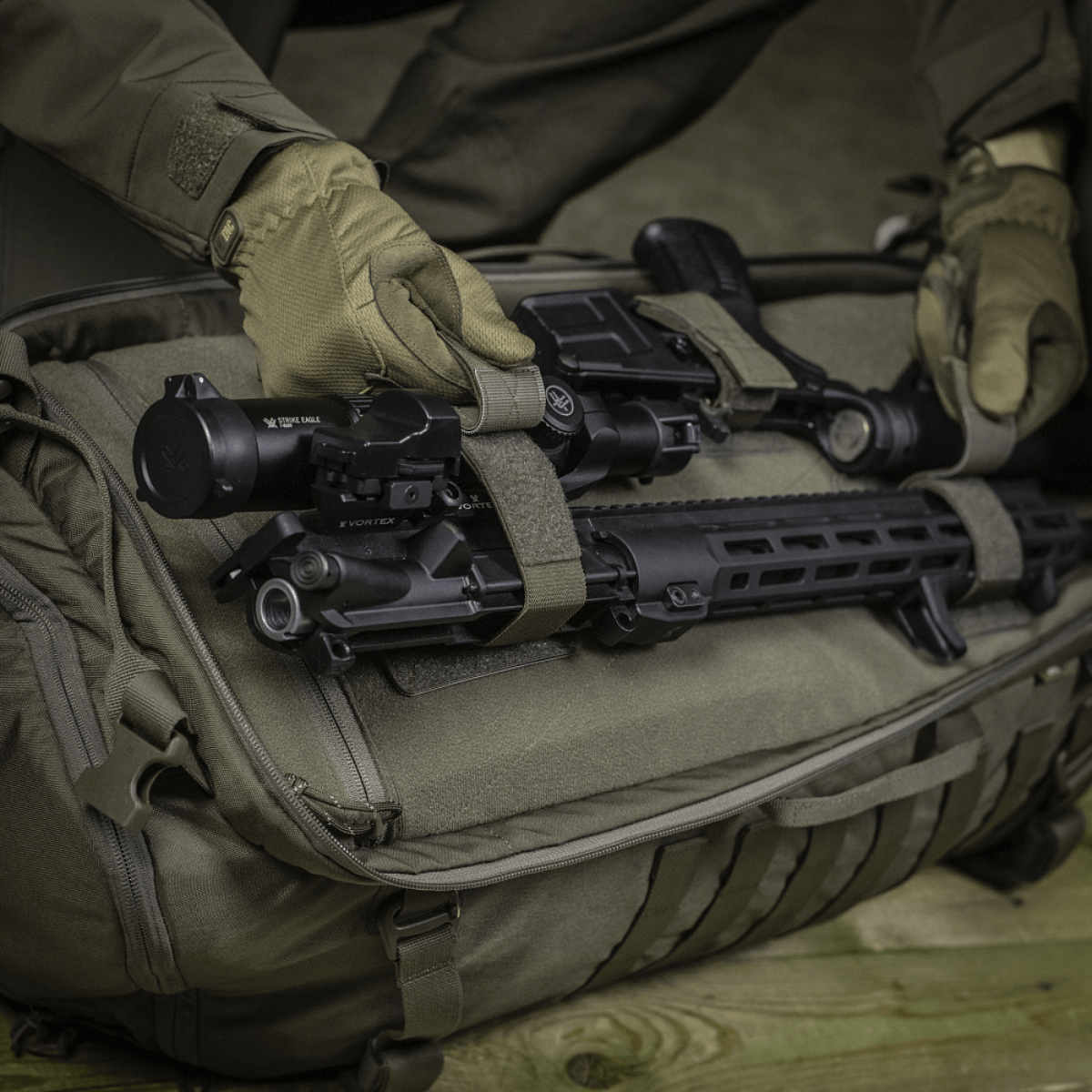 M‑Tac Indlæg til Rygsæk (3 stk) placeret i en rygsæk med våben og tilbehør, viser justerbare indlæg til sikring af AR-15 og AK karbiner.