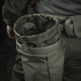 Person wearing M‑Tac Magasinsæk Dump Pouch Lite Elite in green Cordura 500D, attached to belt with MOLLE straps.