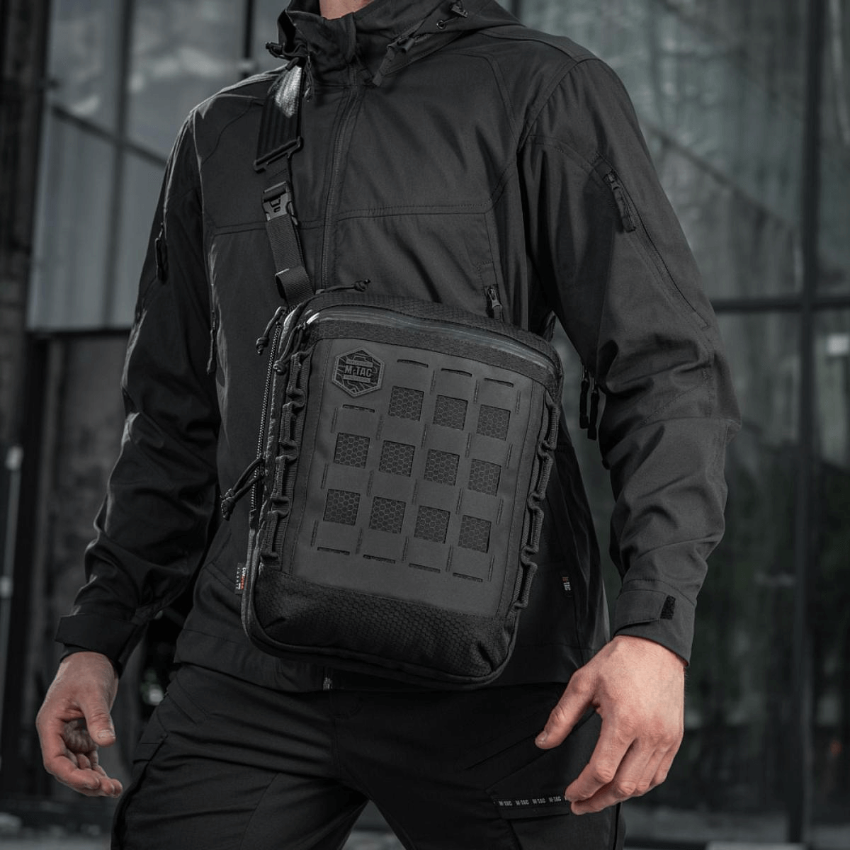 M-Tac Tablet Bag Laser Cut Hex bæres af en mand i sort jakke, robust og praktisk taske til EDC og skjult bæring.