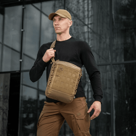 Mand bærer M-Tac Tablet Bag Laser Cut Hex i taktisk miljø, viser taskens MOLLE system og holdbare materiale.