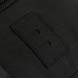 Sort tekstil close-up med syninger og knaphuller, detalje af stofdesign.