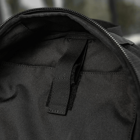 Sort taske med lynlåsdel og sort håndtag, set indefra