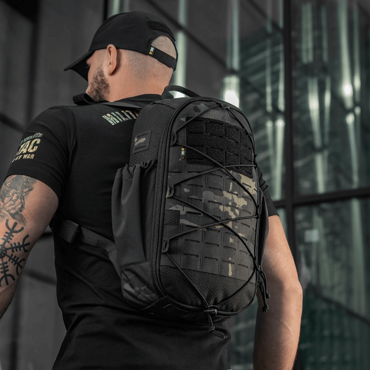 Mand bærer M-Tac STURM Elite Rygsæk med MOLLE Laser Cut frontpanel i urban miljø, taktisk og holdbar designet til kortvarige ophold i felten.