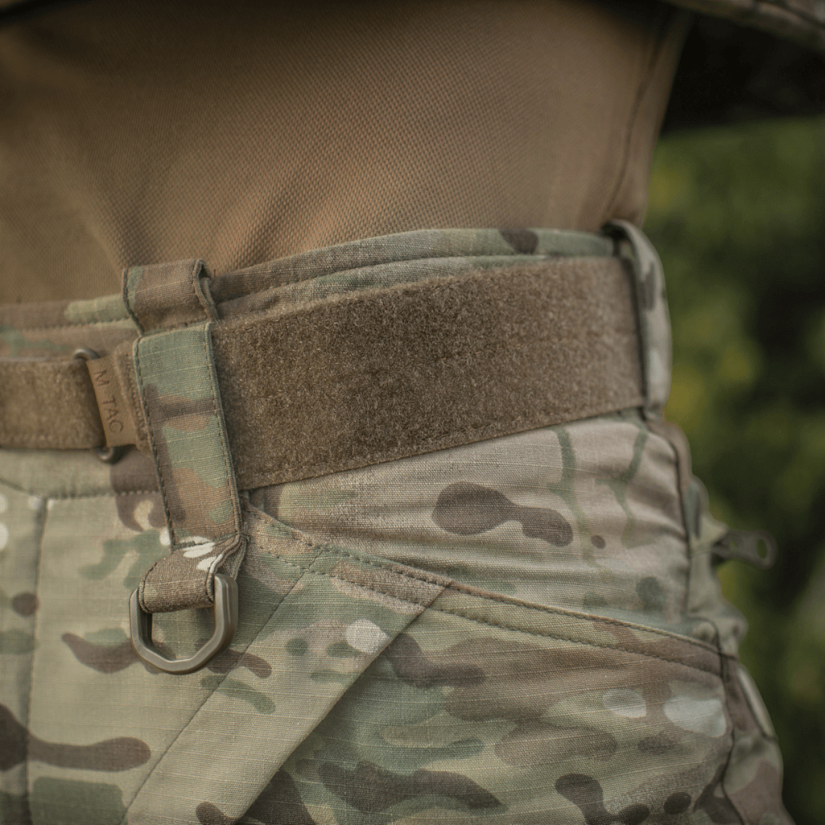 Close-up af M-Tac Tiger Bælte Cobra Buckle monteret på camouflagebukser, ideelt til militær- og taktisk udstyr. Perfekt til MOLLE-kompatibilitet.