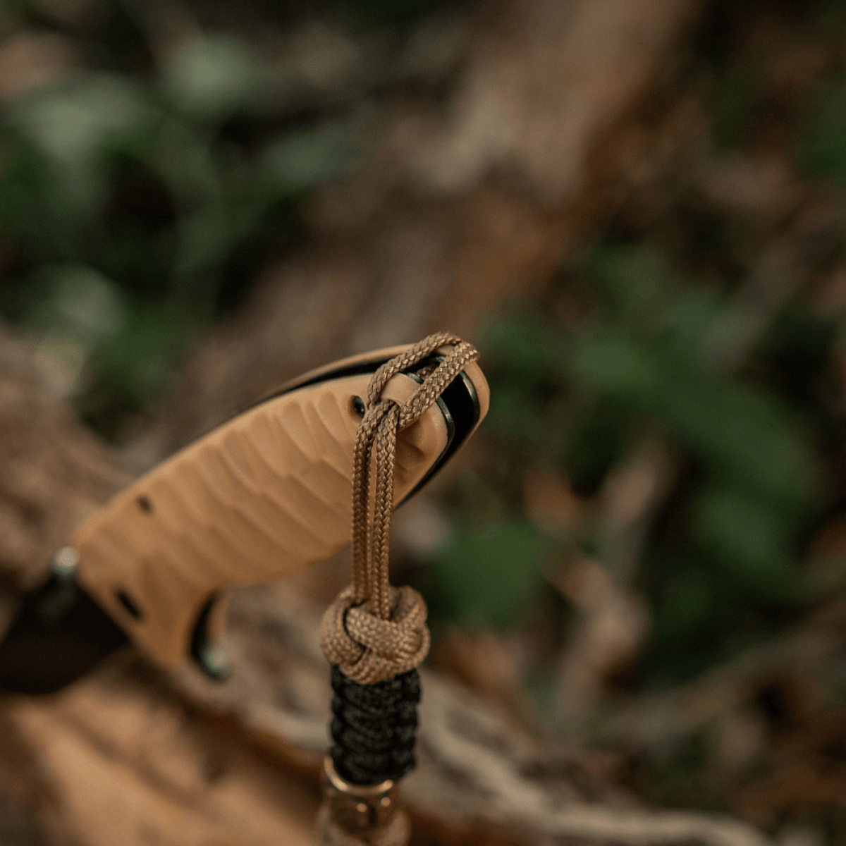 M-Tac Lanyard Scandinavian Small Chinese Knot vedhæftet til kniv, med skandinaviske motiver og dekorativ perle, i naturlig baggrund