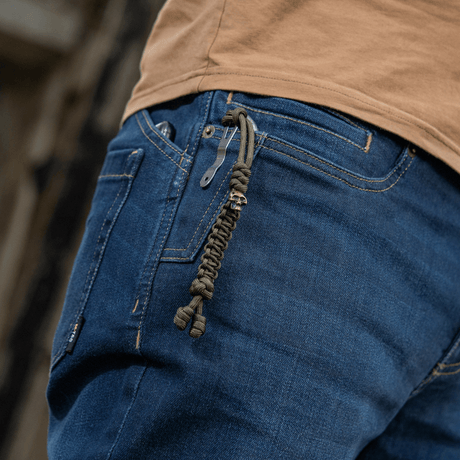 M-Tac Loopy Snake Skull Lanyard i paracord på jeans, stilfuldt og praktisk tilbehør til knive, lygter og andet udstyr.
