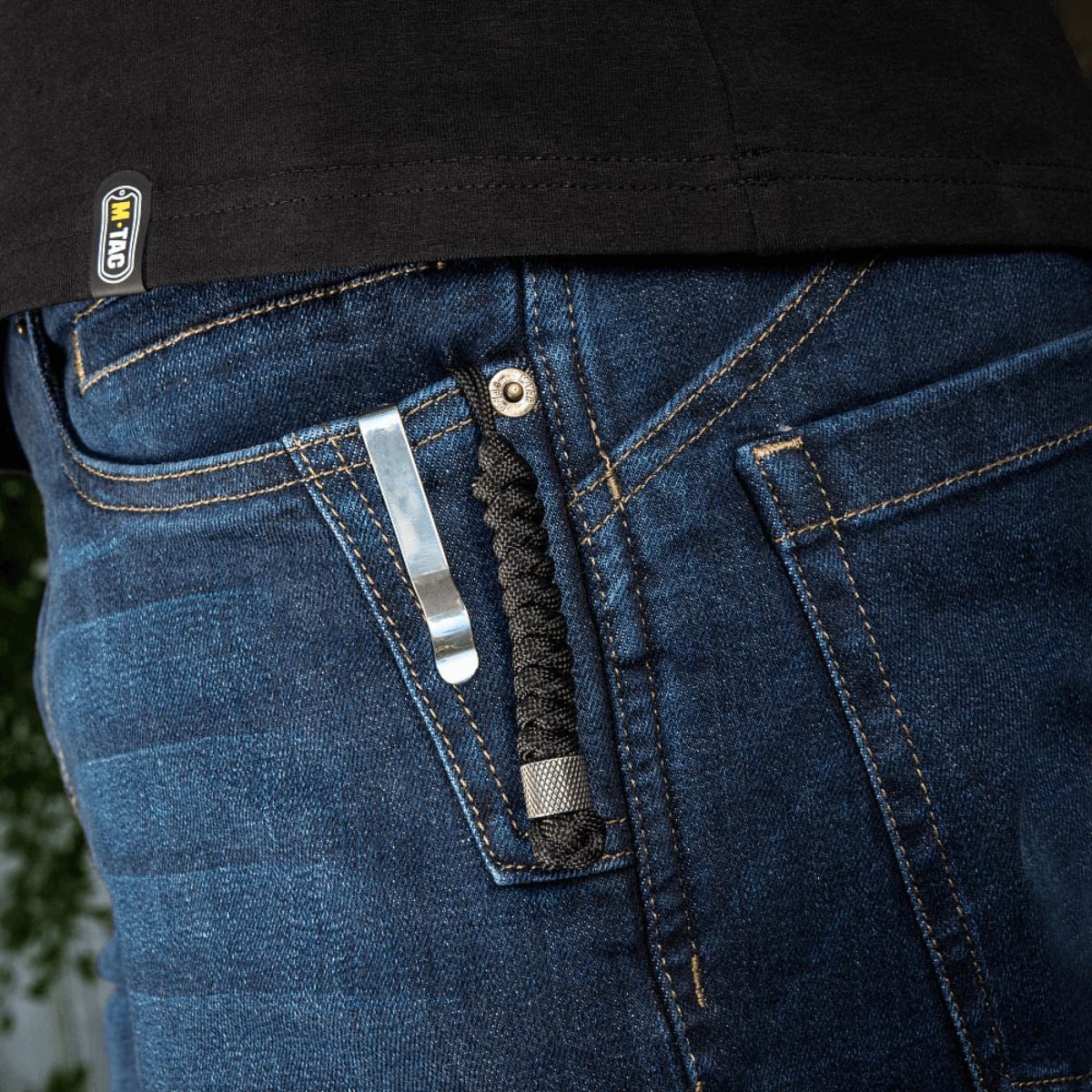 M-Tac Viper Lanyard Stainless Steel i jeanslomme, stilfuldt paracord tilbehør, hurtig adgang til kniv, rustfrit stål, holdbar og fleksibel.