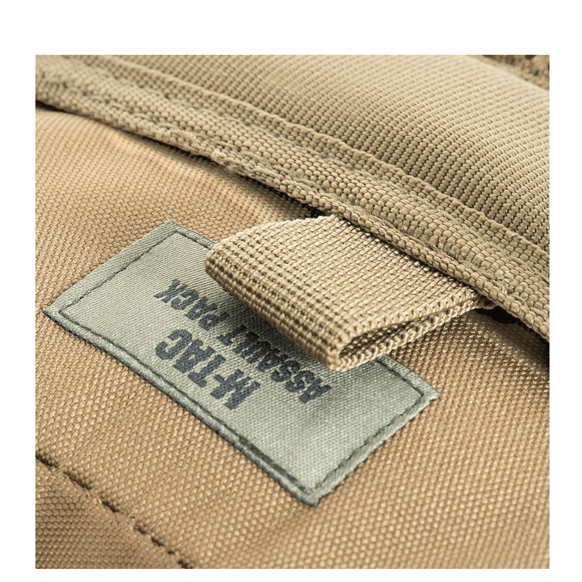 M-Tac Assault Pack med MOLLE-system og polstrede skulderremme, nærbillede af etiket på den beige rygsæk.