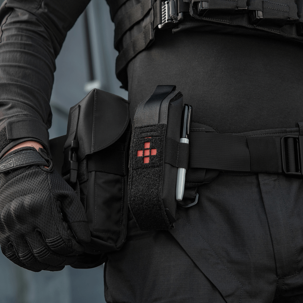 Person i taktisk udstyr med M-Tac Lomme til Tourniquet Closed fastgjort til bæltet i en nødsituation.