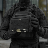 Taktisk operatør holder en M-Tac Admin Pouch Large Elite, perfekt til opbevaring af taktisk udstyr og dokumenter, fremstillet af Cordura 500D.