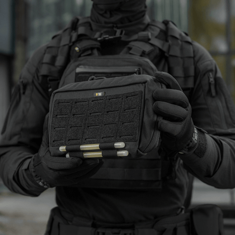 Taktisk operatør holder en M-Tac Admin Pouch Large Elite, perfekt til opbevaring af taktisk udstyr og dokumenter, fremstillet af Cordura 500D.