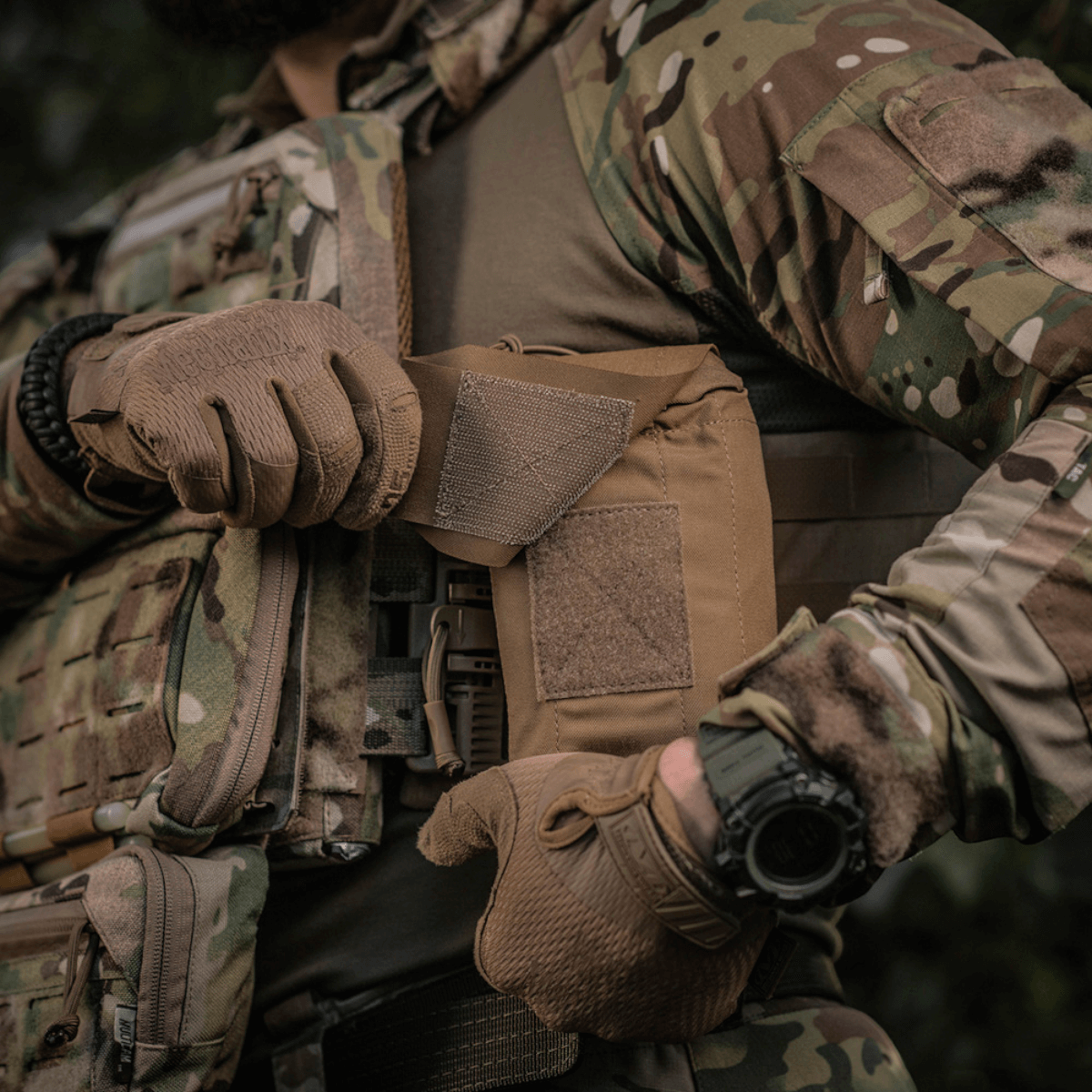 Soldat iført taktisk vest med M-Tac Mediclomme Small Vertical Elite monteret, klar til hurtig adgang til førstehjælpskit