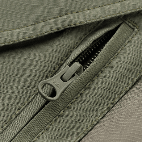 Detaljeret billede af lynlås på M-Tac Shorts Aggressor Gen.II Flex, holdbart rip-stop materiale med Teflon-belægning.