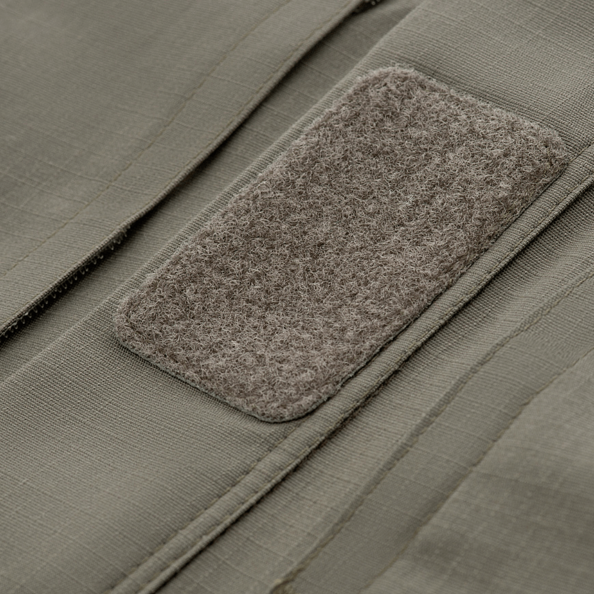 Nærbillede af M-Tac Jakke Patrol Flex med velcro-panel til ID og badges, viser detaljeret stofstruktur og design.