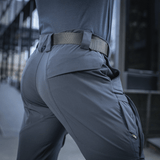Person wearing M-Tac Bukser Rubicon Flex with cargo pockets and stretch fabric, ideal for outdoor activities.