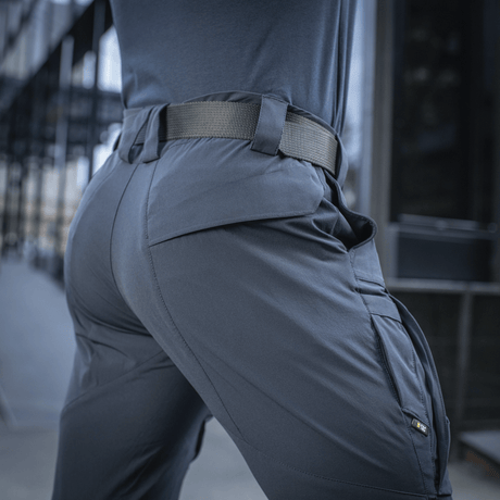 Person wearing M-Tac Bukser Rubicon Flex with cargo pockets and stretch fabric, ideal for outdoor activities.