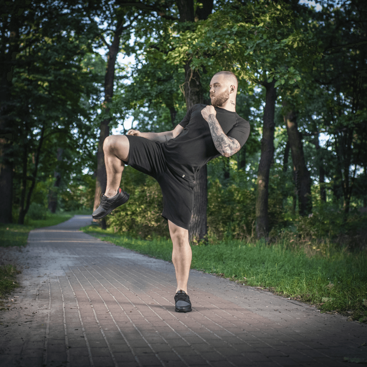 Mand iført M-Tac Shorts Casual Fit Cotton under træning i skoven, sorte shorts med komfortabel pasform og diskret M-Tac logo