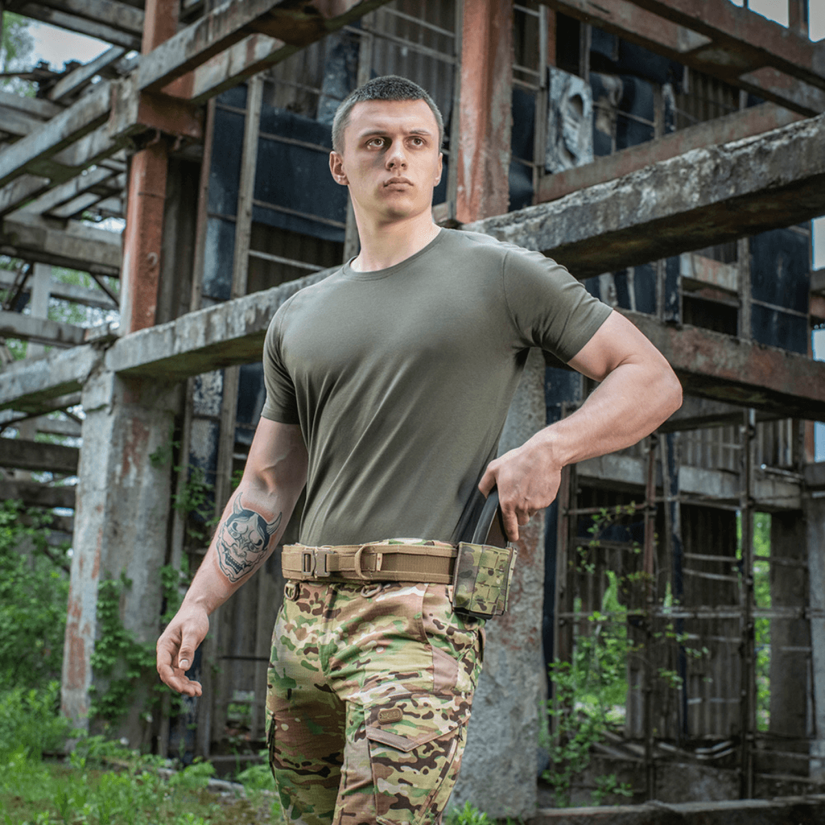 Mand iført M-Tac T-shirt 93/7 Summer i en industriel omgivelse