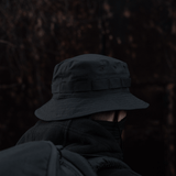 M-Tac Panama Rip-Stop hat with semi-stiff brim, camouflage band, and ventilation holes, worn outdoors in dark setting.