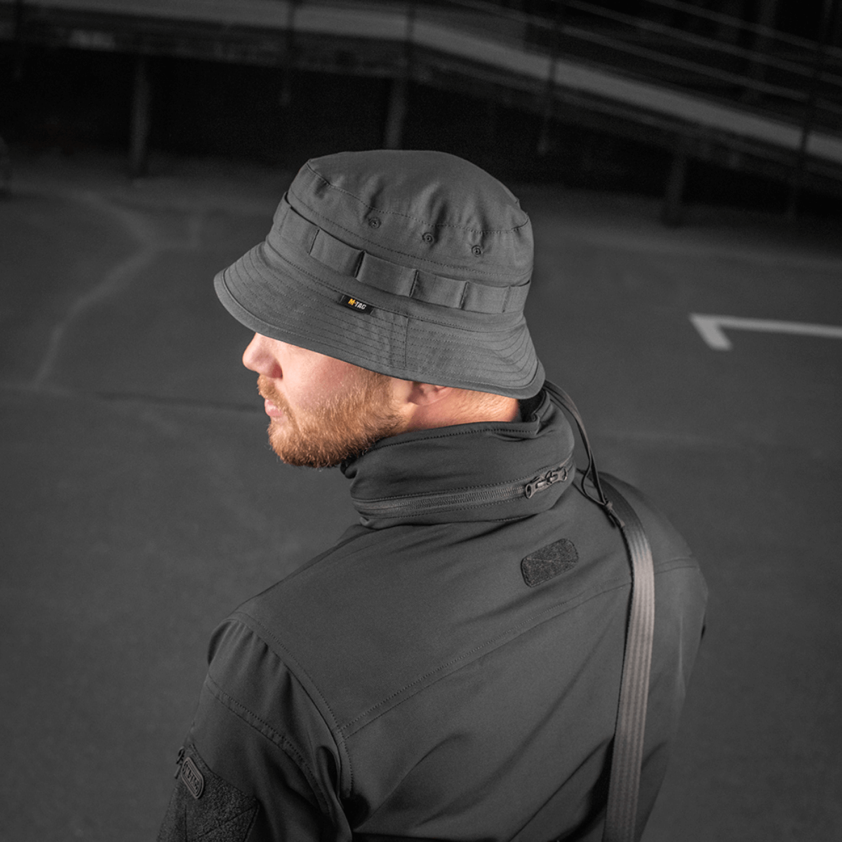 Mand iført M-Tac Panama Rip-Stop hat med semi-stiv skygge og ventilationshuller, set bagfra over skulderen, i en urban setting.