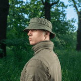 Mand iført M-Tac Panama Rip-Stop army-hat i skovmiljø, viser semi-stiv skygge og ventilationshuller.