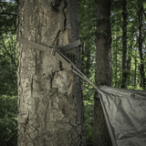 M-Tac Kompressionsrem fastgjort til et træ, ideel til at sikre ekstra udstyr på en rygsæk under vandreture eller taktiske opgaver.