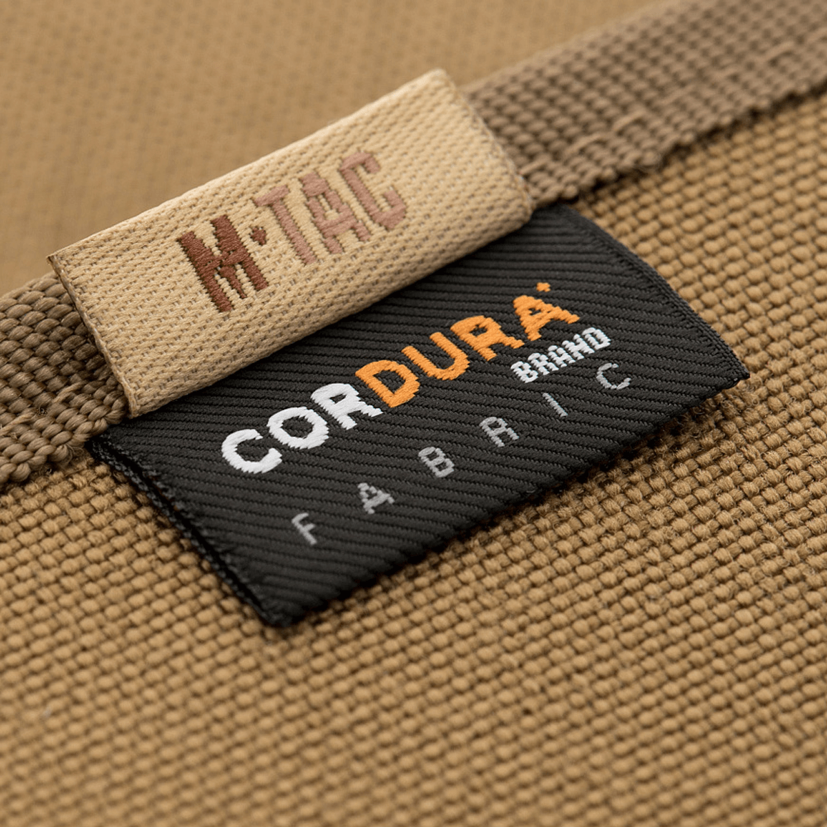 M-Tac Pung med Patch Panel Elite Large fremstillet af holdbart 1000D CORDURA® materiale, detalje af mærkeetiket.