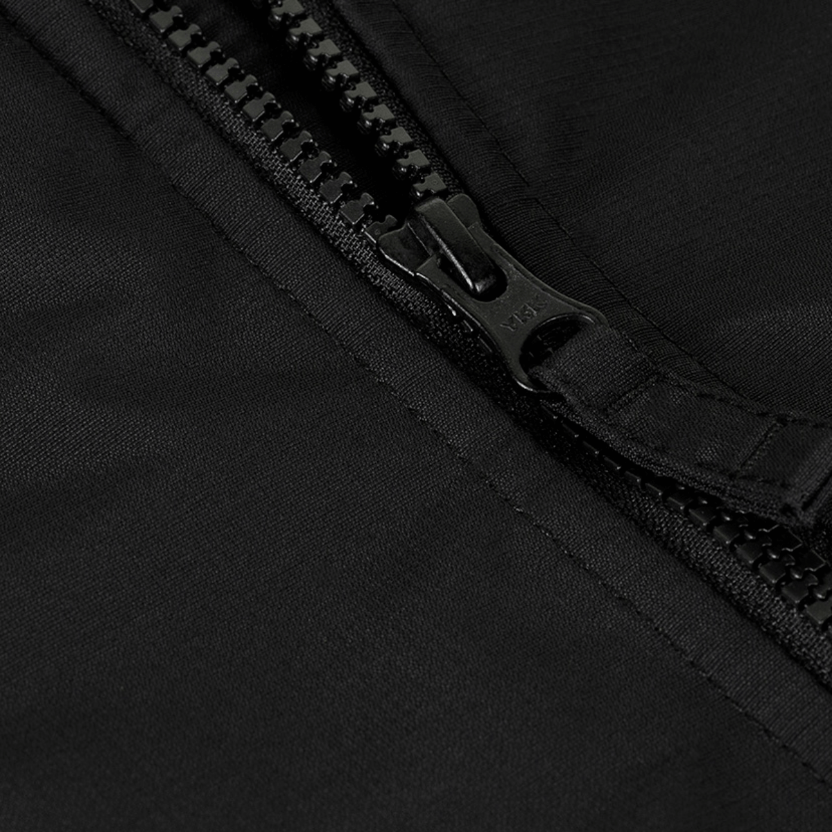 Nærbillede af lynlås på M-Tac Alpha Gen.III Pro Vinterjakke, fremhæver vandtæt nylonmateriale og robust design.